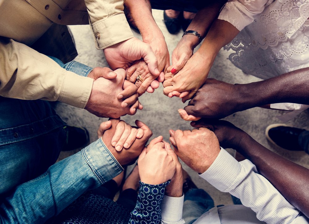 group of diverse people holding hands operation fuel sustainers circle